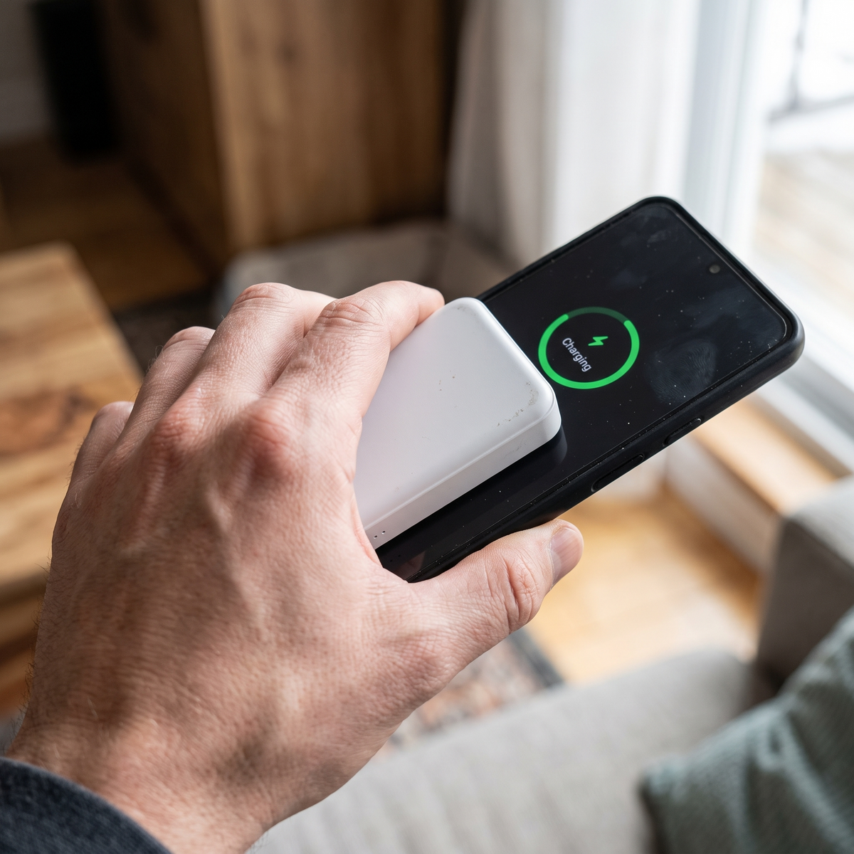 Main fixant la batterie externe MagSafe LE BON DEAL sur un smartphone Android